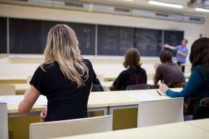 young pretty female college student sitting in a classroom full